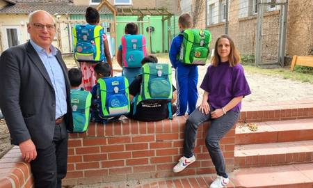 Dekan Ralph Hartmann und Kita-Leiterin Franziska Geschwind bei der Schulranzenspende